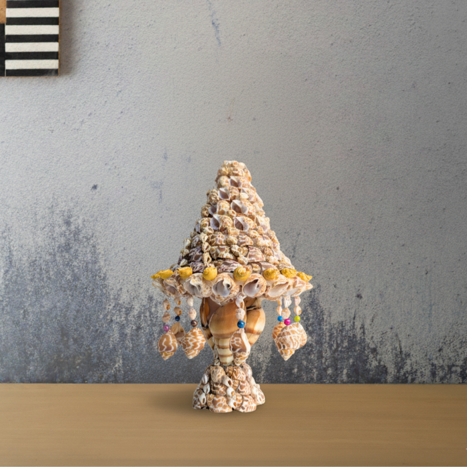 Decorative shell fancy table lamp on a wooden surface with a gray wall background