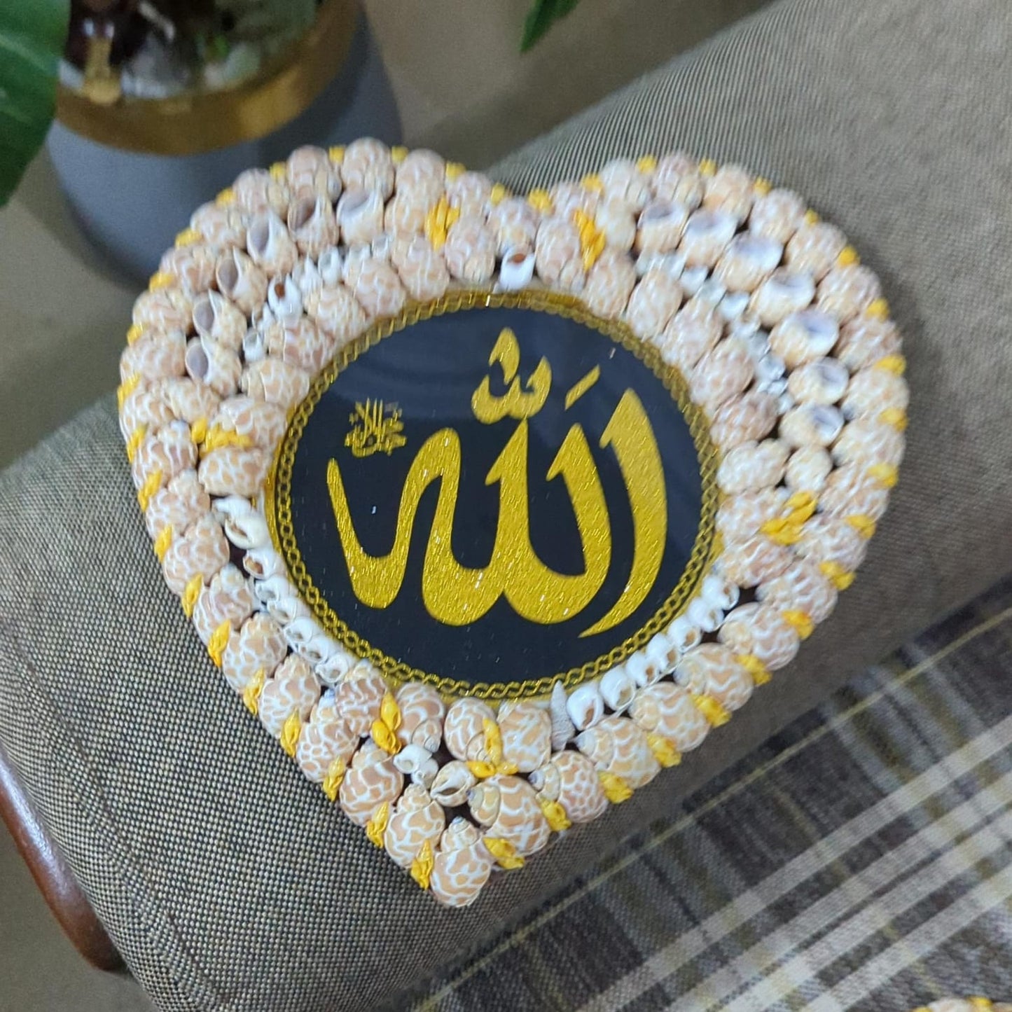 Heart-shaped decorative item with 'Allah' text on a textured surface