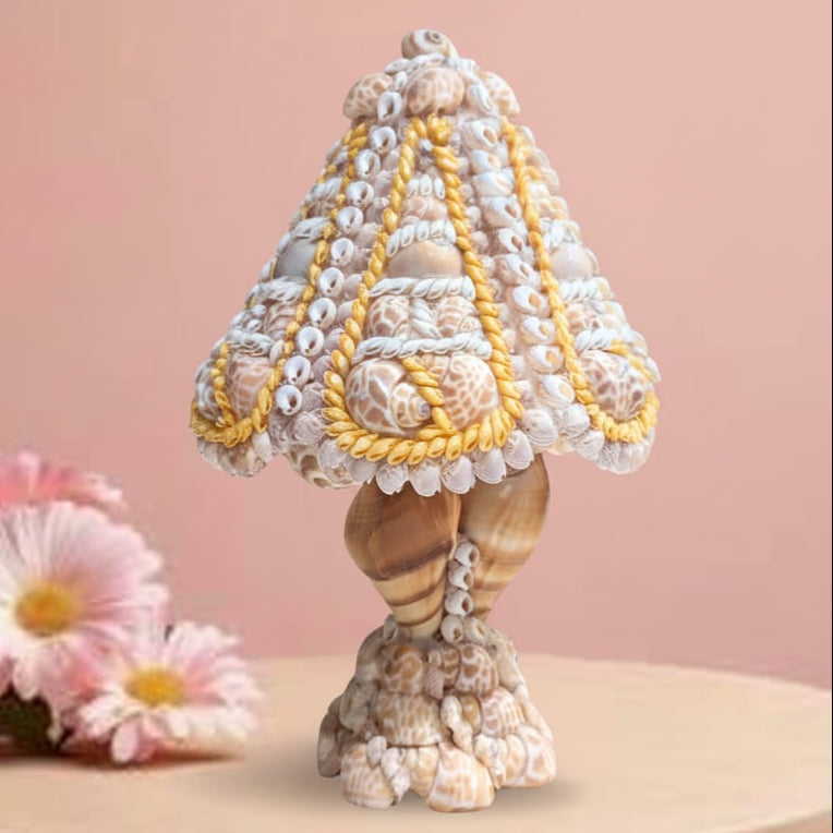 Decorative shell table lamp on a pink background with flowers