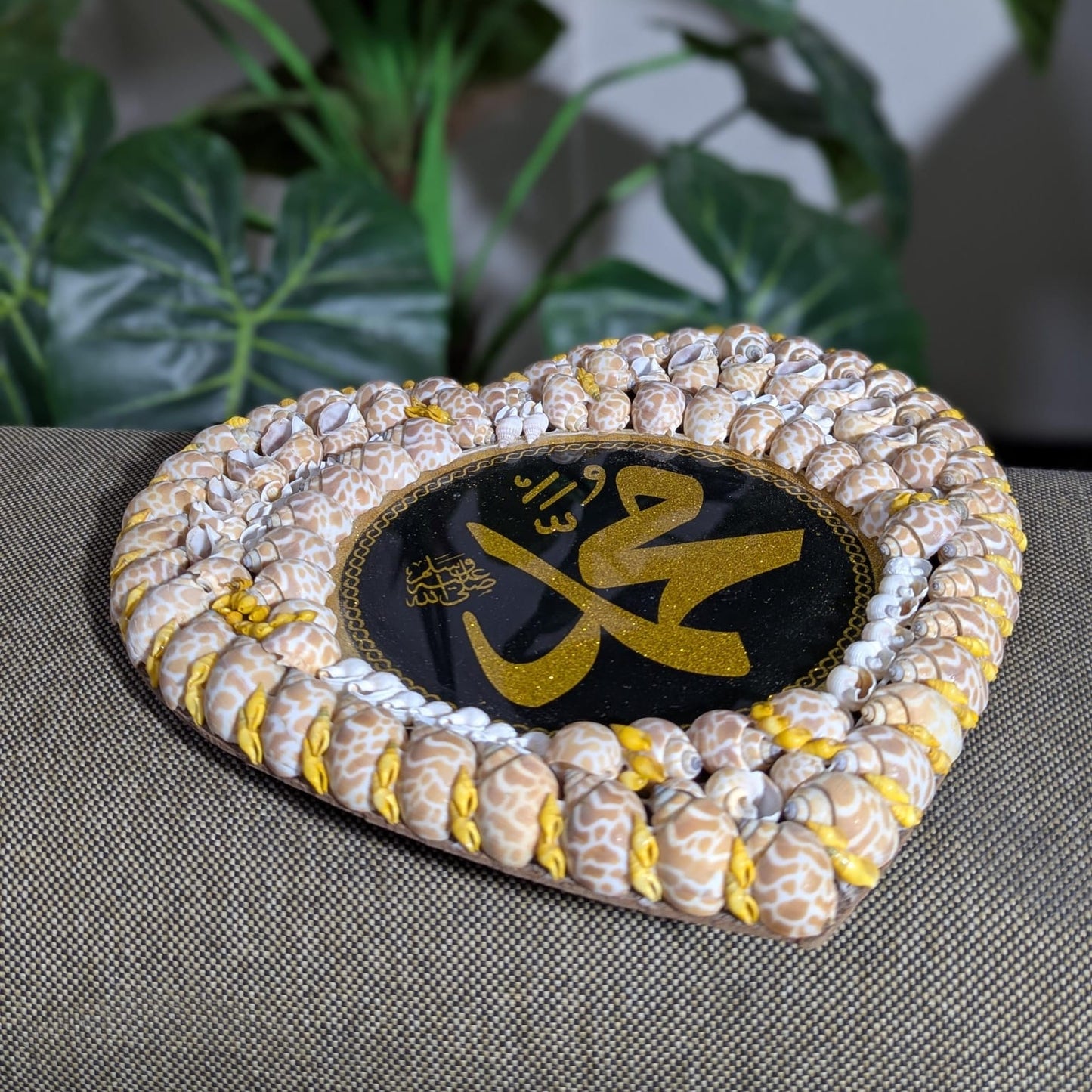 Decorative item with shell border and central text on a textured surface