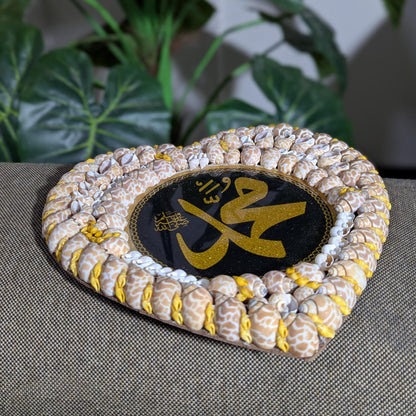 Decorative item with shell border and central text on a textured surface