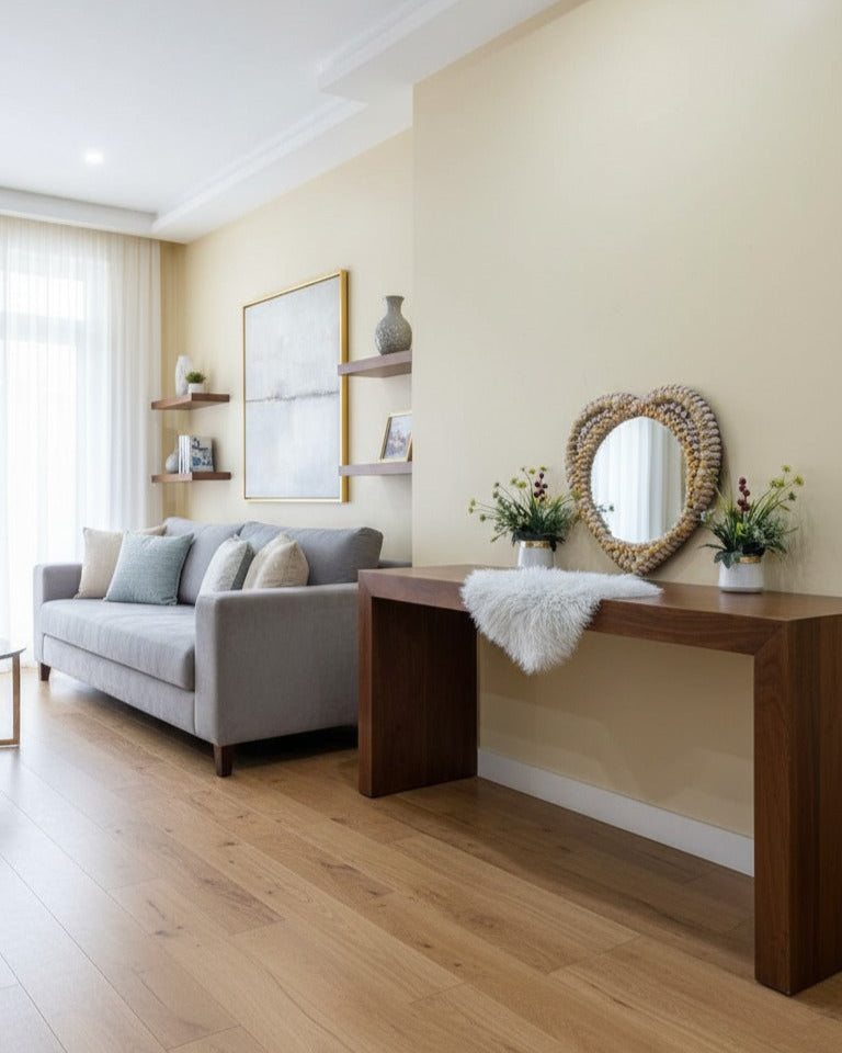 Living room with a gray sofa, wooden console table, heart shape seashell mirror and decorative items.