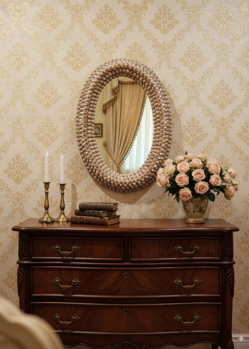 Wooden dresser with decorative mirror, candles, and flowers against a patterned wall.