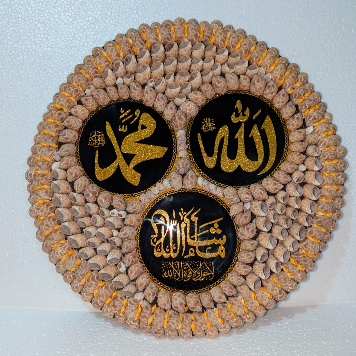 Decorative item with 'Allah' 'Muhammad' 'MashaALlah' text on a textured surface