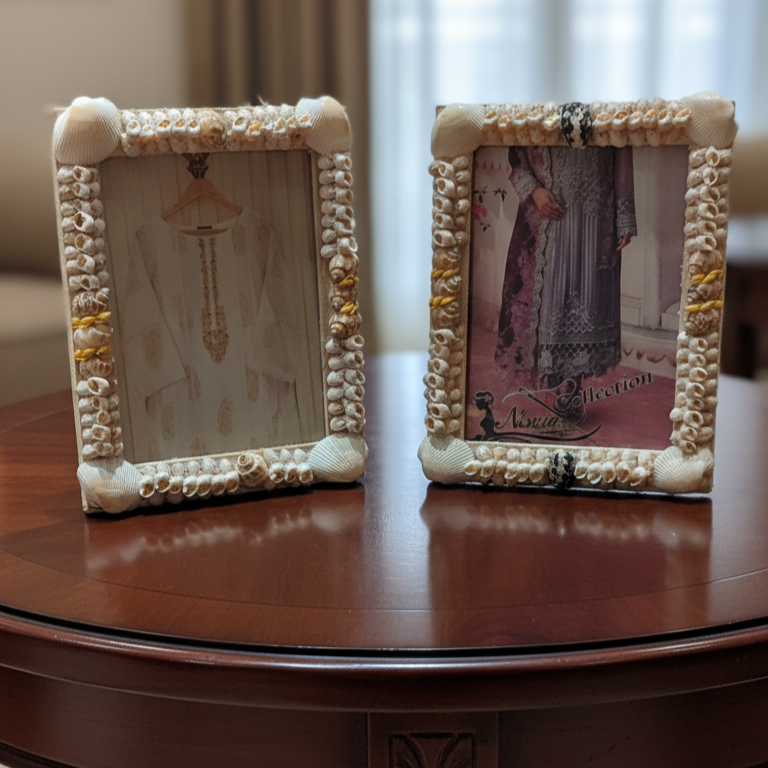 Two decorative picture frames on a wooden table with blurred background