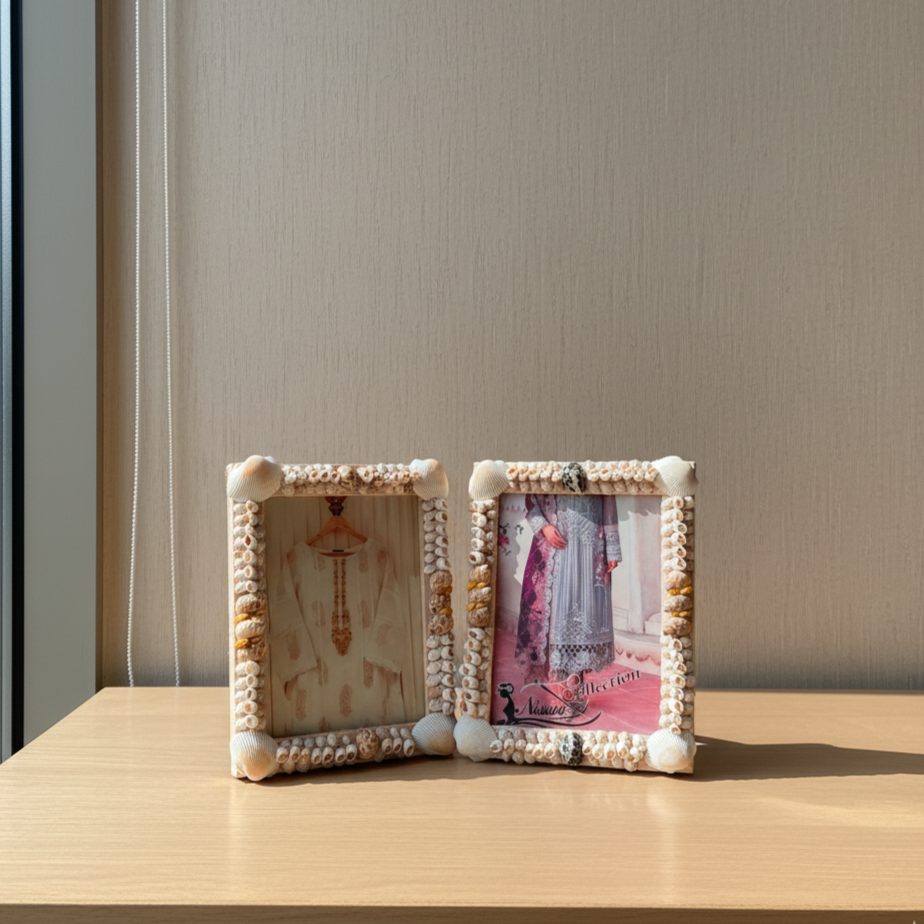 Two decorative picture frames on a wooden surface with a neutral background