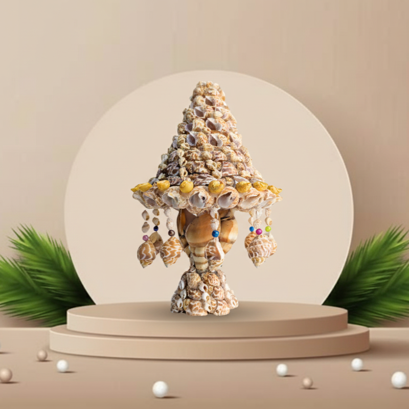 Decorative shell table lamp on a beige platform with green leaves and small white balls on a beige background
